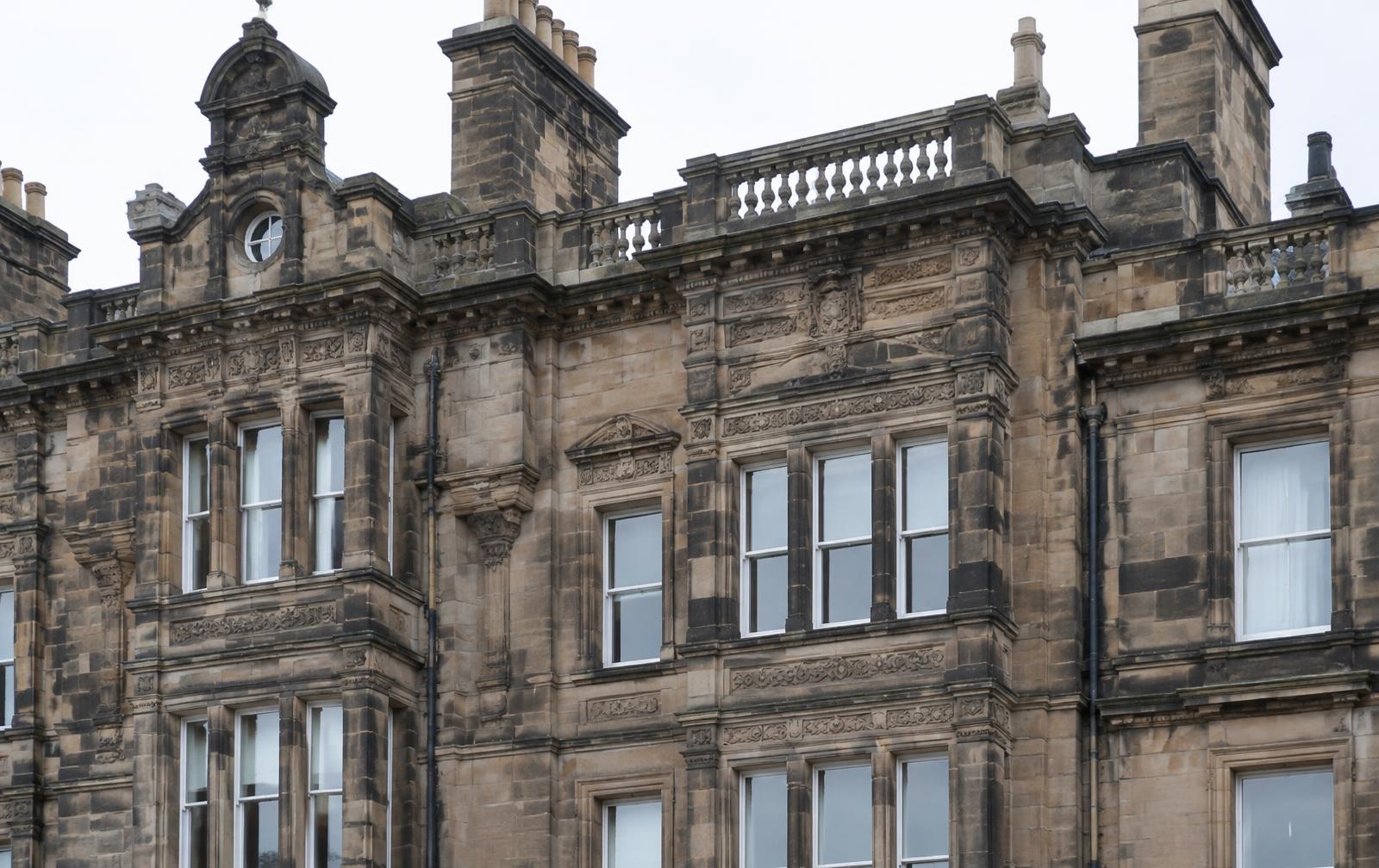 Carved Scottish sandstone building elevation with soot-darkened weathering